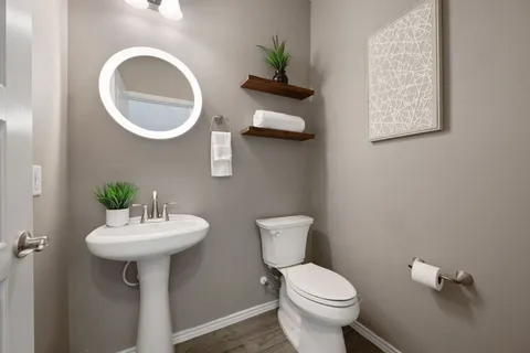a bathroom with a toilet sink and mirror
