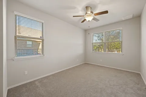 an empty room with fan and windows