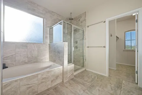 a spacious bathroom with a glass shower door and a shower