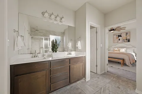 a en suite bathroom with a double vanity sink and a mirror