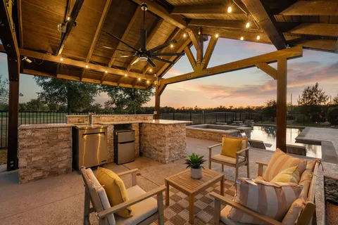 a view of a patio with couches chairs dining table and chairs with wooden floor