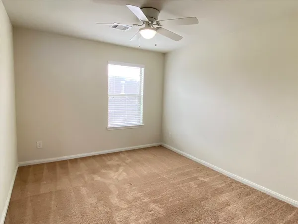 an empty room with a window and a ceiling fan