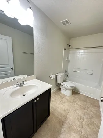 a spacious bathroom with a bathtub shower sink mirror and toilet