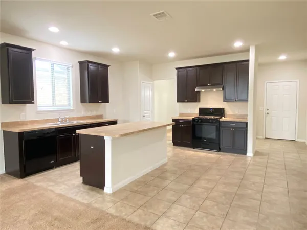 a large kitchen with stainless steel appliances granite countertop a stove and a sink
