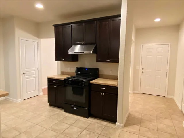 a kitchen with a black stove top oven and cabinets