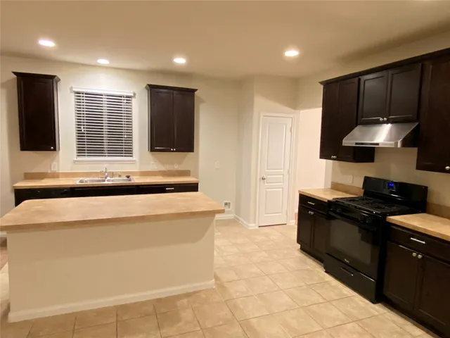 a kitchen with stainless steel appliances granite countertop a refrigerator and a stove