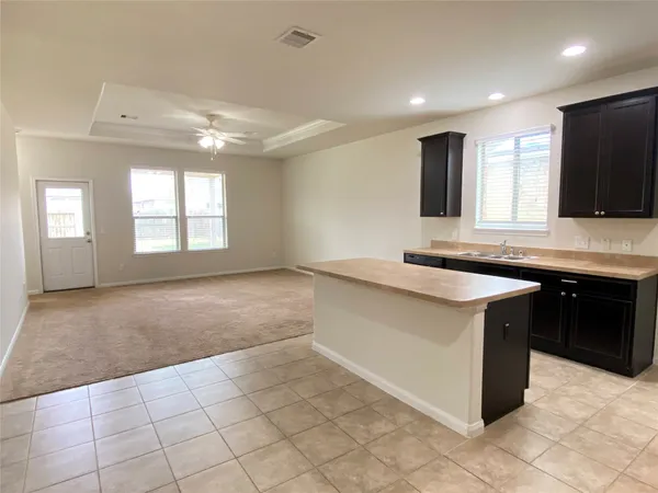 a large kitchen with kitchen island granite countertop a sink and a stove