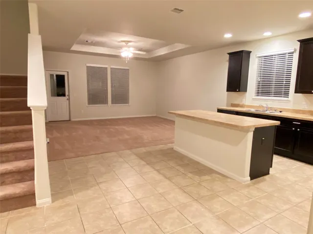 a view of a kitchen with stainless steel appliances granite countertop a sink and a stove