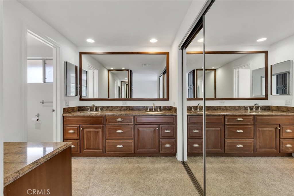 19034 Killoch Way Porter Ranch, CA 91326 - Photo 29 of 42 a spacious bathroom with a granite countertop sink and a mirror