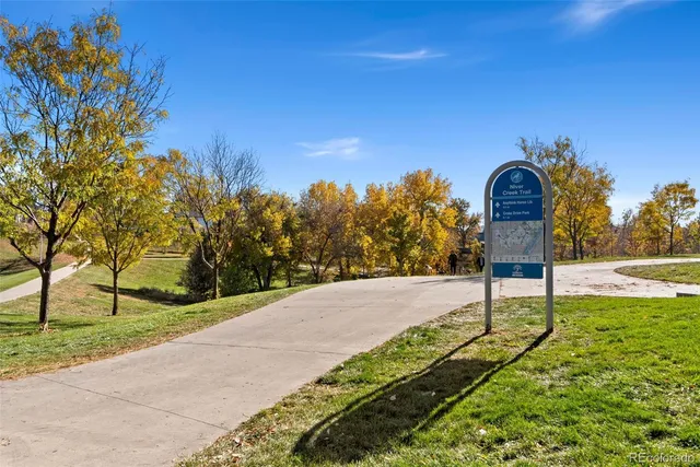 a view of a yard with flower plants and wooden fence