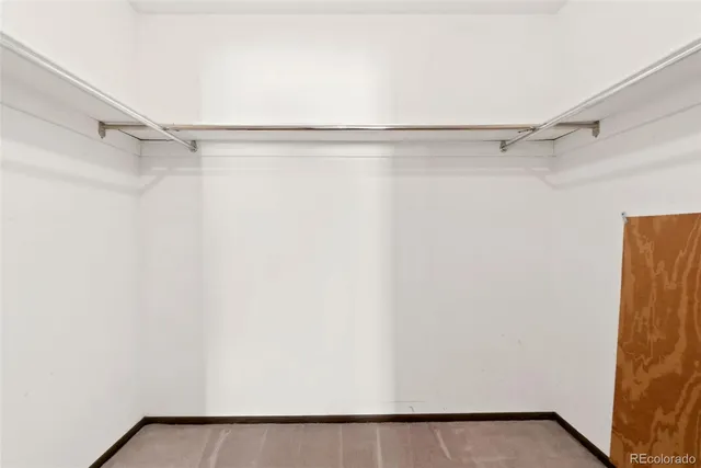 a view of walk in closet with empty racks