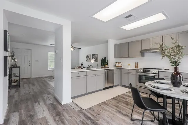 a kitchen with a table chairs refrigerator and cabinets