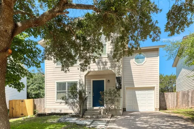 a front view of a house with a tree