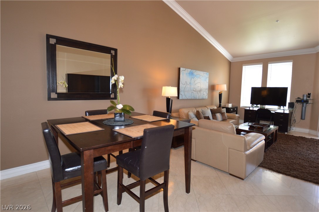 220 East Flamingo Road, Unit 327 Las Vegas, NV 89169 - Photo 12 of 13 Dining area with crown molding connects to a naturally illuminated living space.