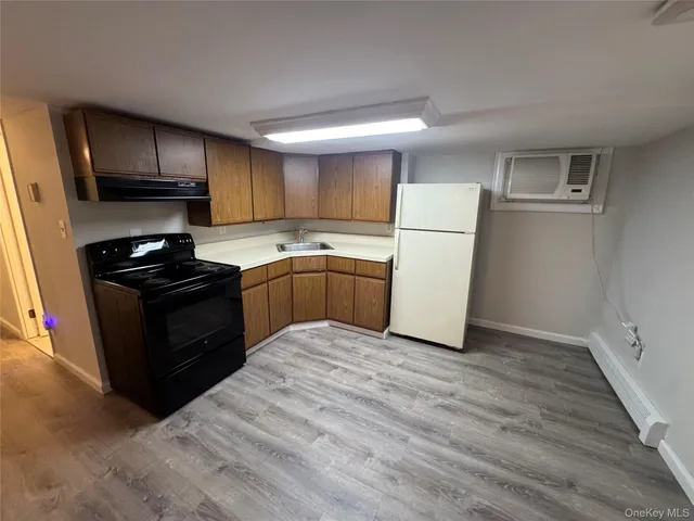 a kitchen with a refrigerator sink and wooden cabinets