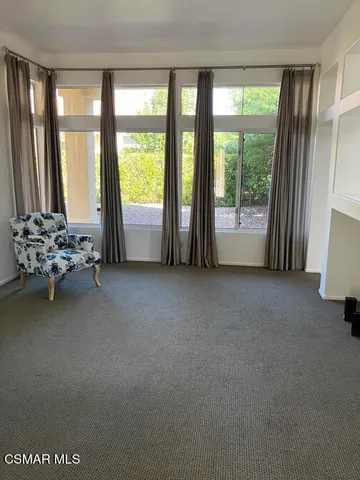 a living room with furniture and large windows