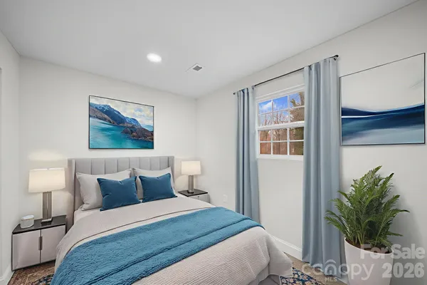 a bedroom with a bed and a lamp on dresser