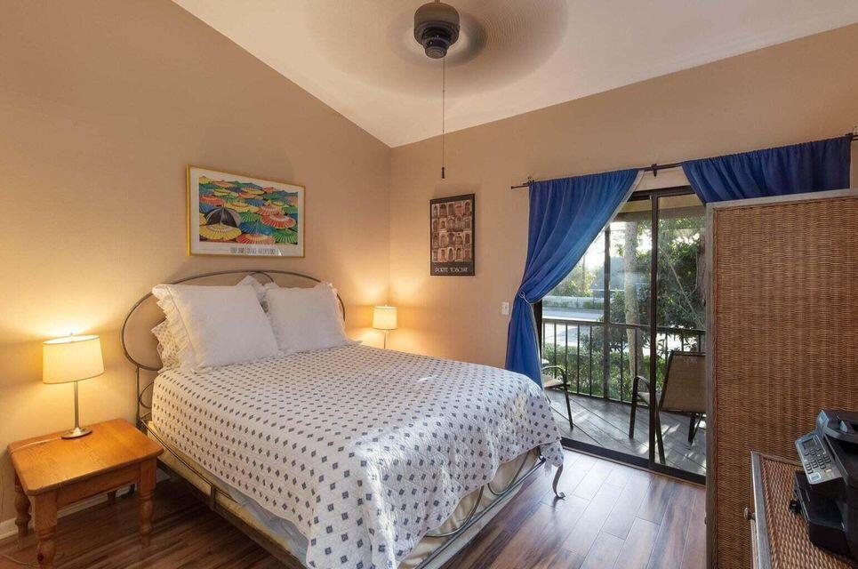 13045 Albright Court, Unit 12 Wellington, FL 33414 - Photo 8 of 11 a bedroom with a bed and a large window