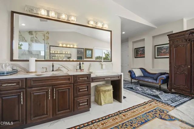 a bathroom with a granite countertop bathtub shower sink vanity and toilet