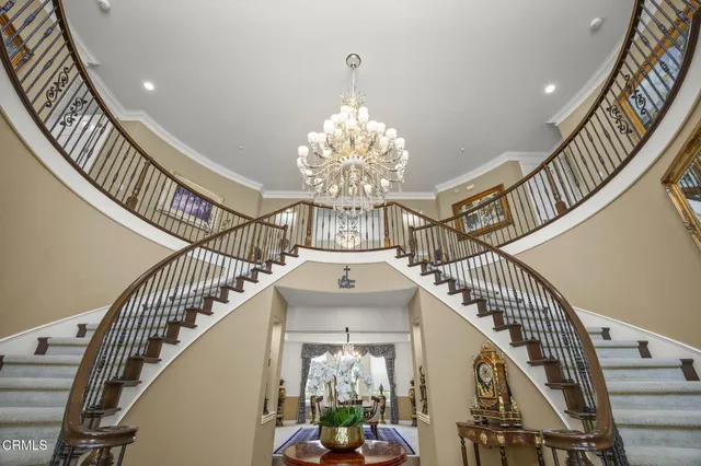 a view of a dining room and livingroom with furniture wooden floor a chandelier and a rug