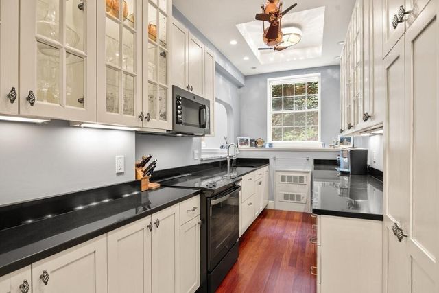 a kitchen with stainless steel appliances granite countertop a sink a stove and cabinets