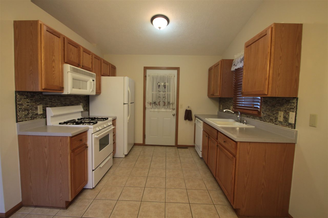 5467 Torque Road Loves Park, IL 61111 - Photo 5 of 21 a kitchen with stainless steel appliances granite countertop a stove a sink and a refrigerator