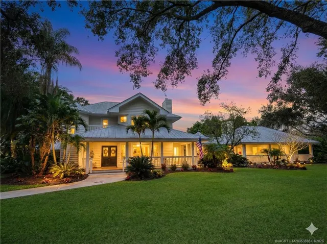 a view of a house with a big yard and potted plants