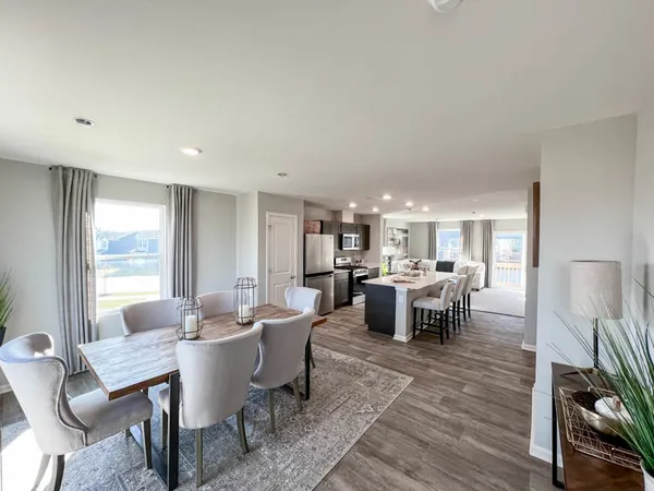 a kitchen with a dining table chairs refrigerator and cabinets