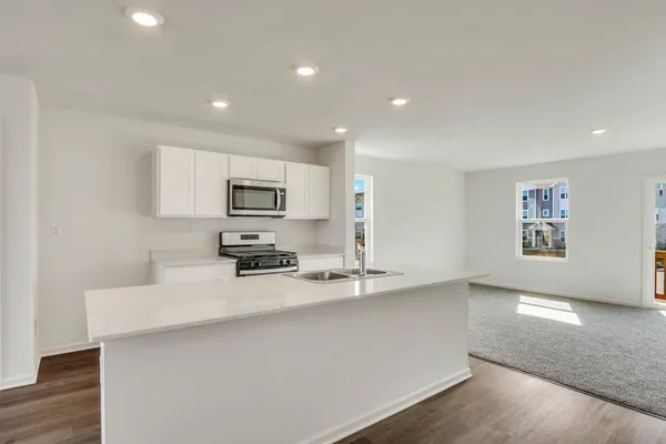 a kitchen with stainless steel appliances a sink a stove a microwave a sink a refrigerator and cabinets