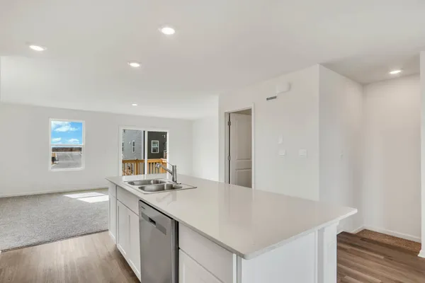 a kitchen with granite countertop a sink and a stove with wooden floor