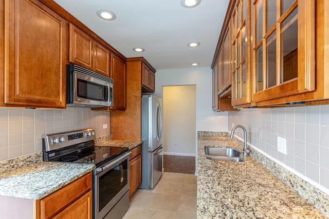 a kitchen with stainless steel appliances granite countertop a stove a sink a microwave and refrigerator