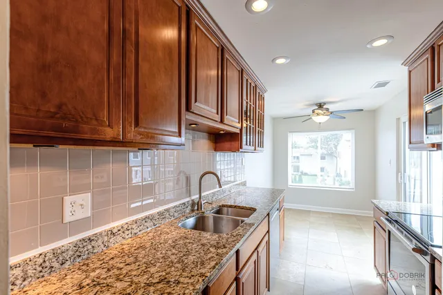 a kitchen with granite countertop a sink cabinets and window