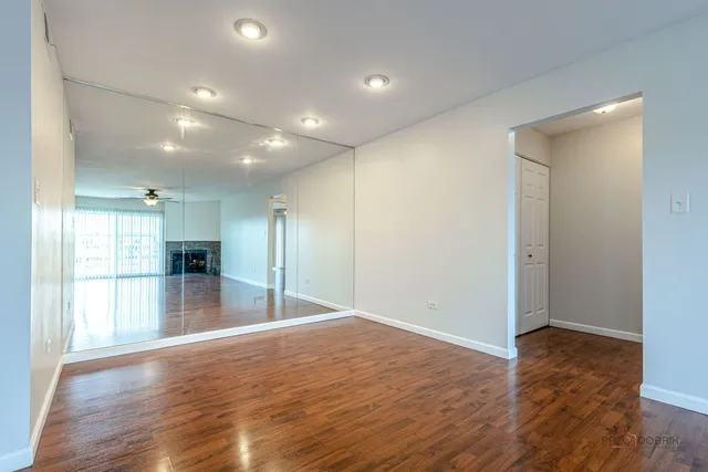 a view of empty room with wooden floor