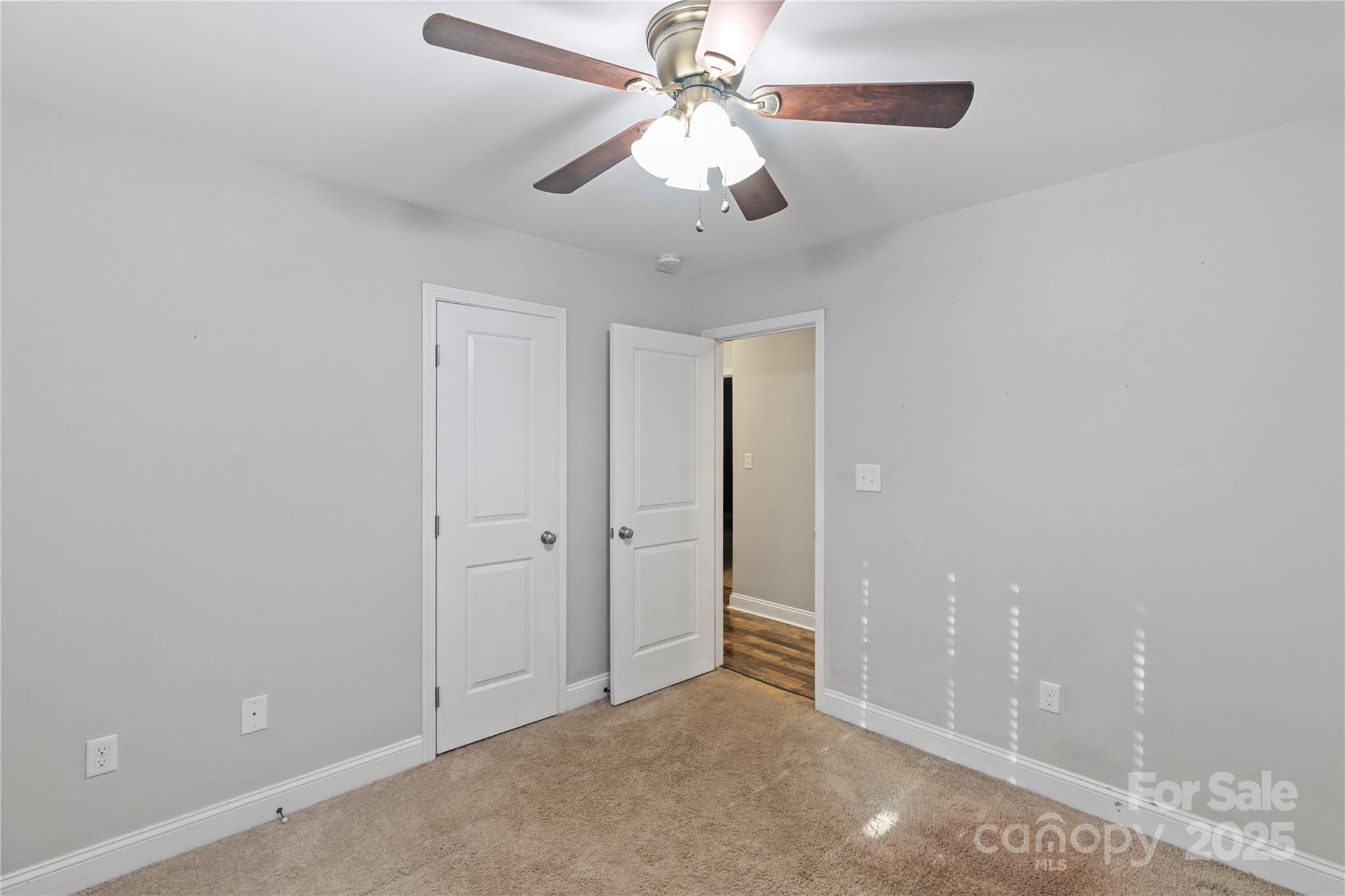 758 Main Street Southwest Concord, NC 28027 - Photo 19 of 25 an empty room with chandelier fan and windows
