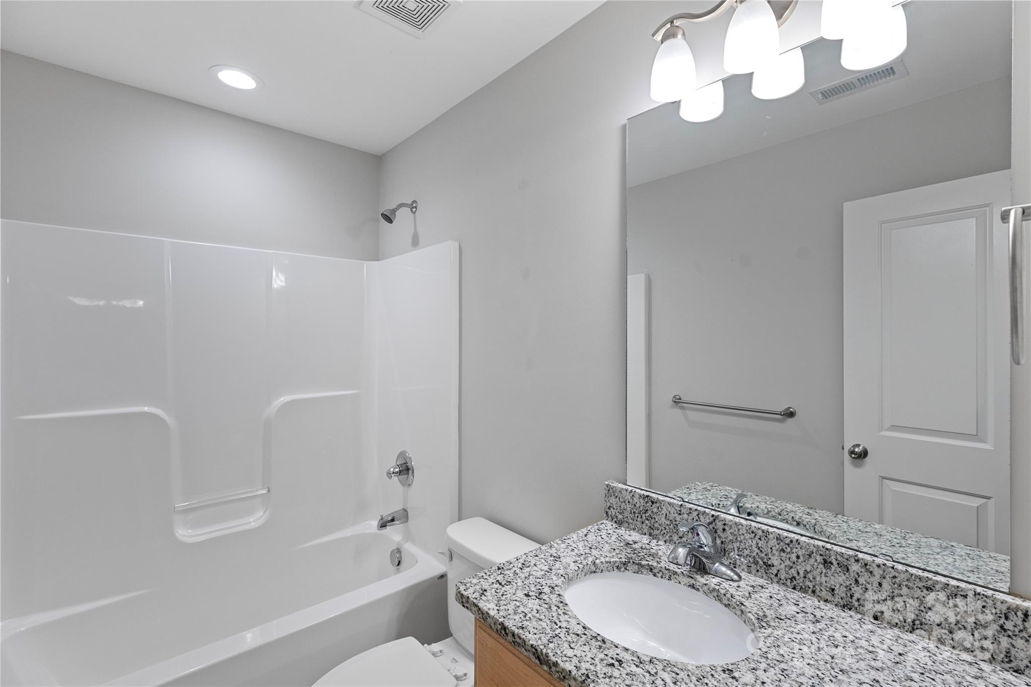 758 Main Street Southwest Concord, NC 28027 - Photo 23 of 25 a bathroom with a granite countertop sink a toilet and shower