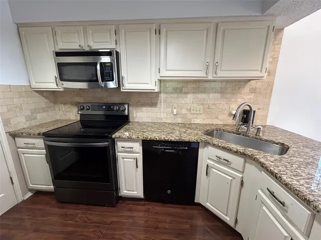 a kitchen with granite countertop a stove and a sink