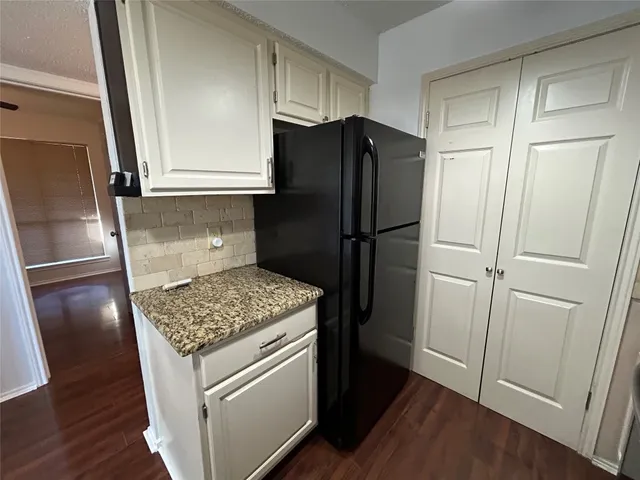 a kitchen with a refrigerator and cabinets