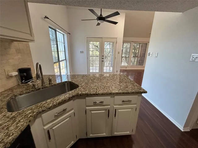 a view of a kitchen counter space a sink a window and wooden floor