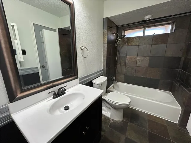 a bathroom with a sink a toilet a mirror and shower