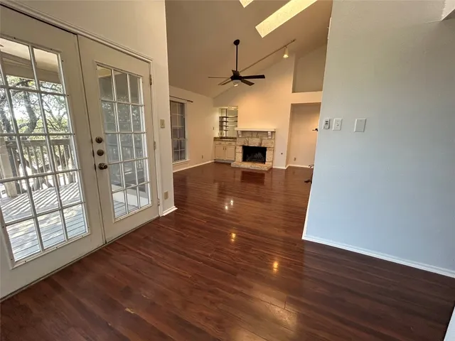a view of empty room with wooden floor and fireplace