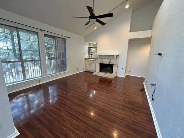 a view of empty room with wooden floor and fireplace