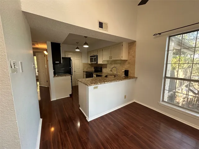 a kitchen with a sink and wooden floor