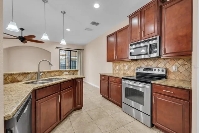 a kitchen with a sink stove top oven and cabinets