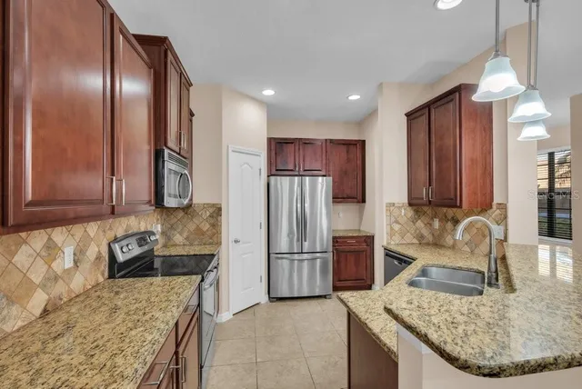 a kitchen with stainless steel appliances granite countertop a sink stove and microwave