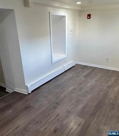 an empty room with wooden floor and closet