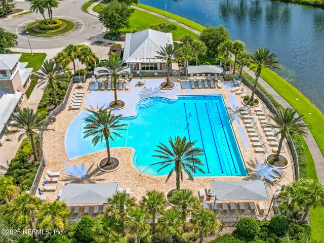 an aerial view of a swimming pool with outdoor seating