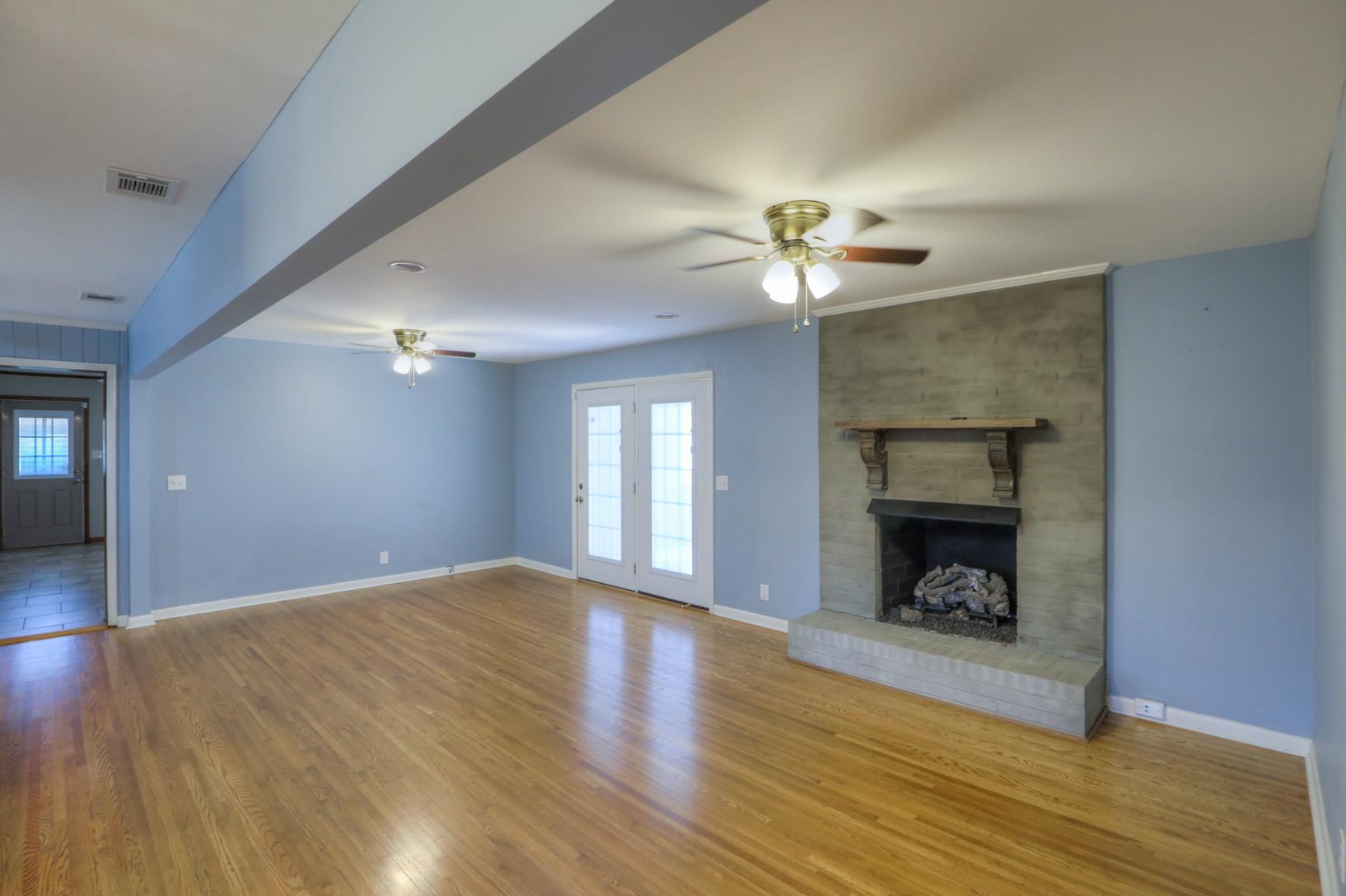 3144 Battle Creek Road Springfield, TN 37172 - Photo 10 of 28 a view of an empty room with wooden floor fireplace and a window