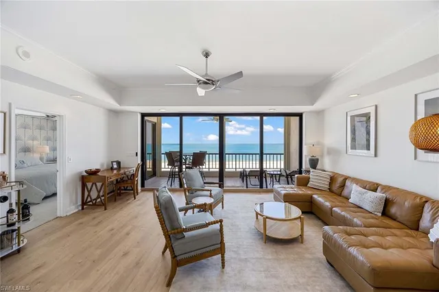 a living room with furniture and a large window with balcony view