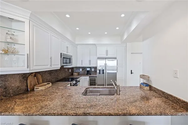 a kitchen with stainless steel appliances granite countertop a sink stove and cabinets