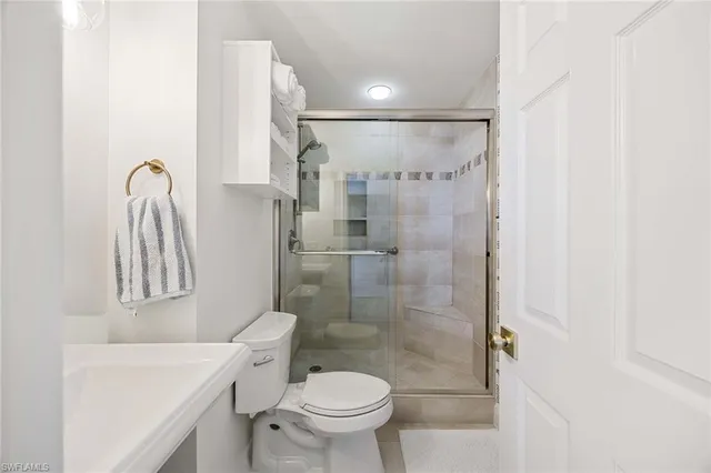 a bathroom with a shower a toilet and a sink